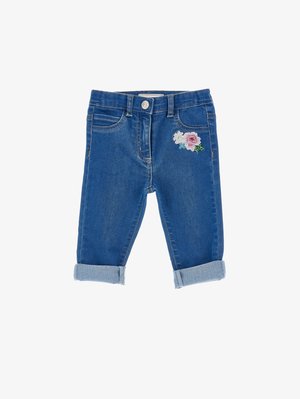 Blaue Jeans für Kleinkinder mit hochgekrempelten Bündchen und einem kleinen, bestickten Blumenpatch auf dem rechten Oberschenkel.