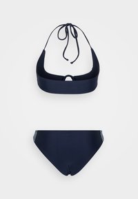 Marinblå bikini-set med halterneck-top som har bakre knytning och en nyckelhålsdetalj; bottnarna har en enfärgad ton och subtila texturdetaljer.