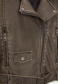 Bruine neplederen bikerjack met ritsen, drukknoopsluitingen en een gestructureerde afwerking. Voorzien van een gerande kraag en een tailleband.