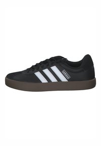 Black athletic shoes featuring three white stripes, a textured synthetic upper, lace-up closure, and a brown rubber sole.