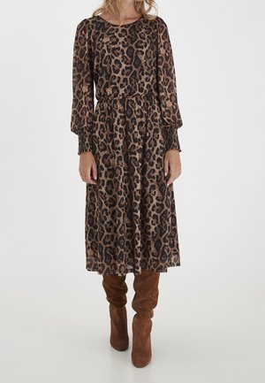 Leopardenmuster-Kleid mit langen Puffärmeln, elastischen Bündchen, gerafftem Taillenbereich und einem fließenden Rock, kombiniert mit braunen Kniefällen.