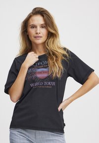 Juodas medvilninės marškinėliai trumpomis rankovėmis, su spalvingu "World Tour" grafikiniu spaudiniu ir laisvu siluetu.
