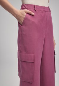Cargo broeken in een levendige roze stof, met een zijzak met klep, een relaxte pasvorm en een gladde textuur.