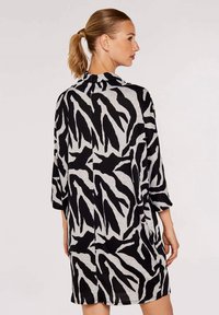 Zebramuster-Kleid in Schwarz und Grau, aus weichem Stoff gefertigt. Verfügt über eine legere Passform, lange Ärmel und einen hohen Kragen.