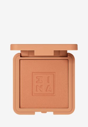 Compact blush in a square, soft peach tone with a textured surface and embossed logo. Lid features a hinge for easy opening.