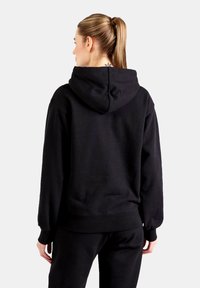 Black hooded sweatshirt with long sleeves, ribbed cuffs and hem, soft fleece texture, features a central seam at the back of the hood.