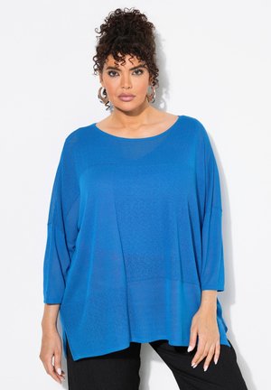 Top blu loose-fit con scollatura tonda e maniche a tre quarti. Presenta pannelli testurizzati e spacchi laterali per il comfort.