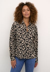 Blusa con stampa leopardata in nero e beige, con colletto, chiusura con bottoni sul davanti, maniche lunghe e vestibilità comoda.