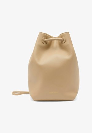 Beżowa skórzana torba typu bucket ze sznurkiem, cienkim paskiem i subtelnym złotym logo z przodu na białym tle.