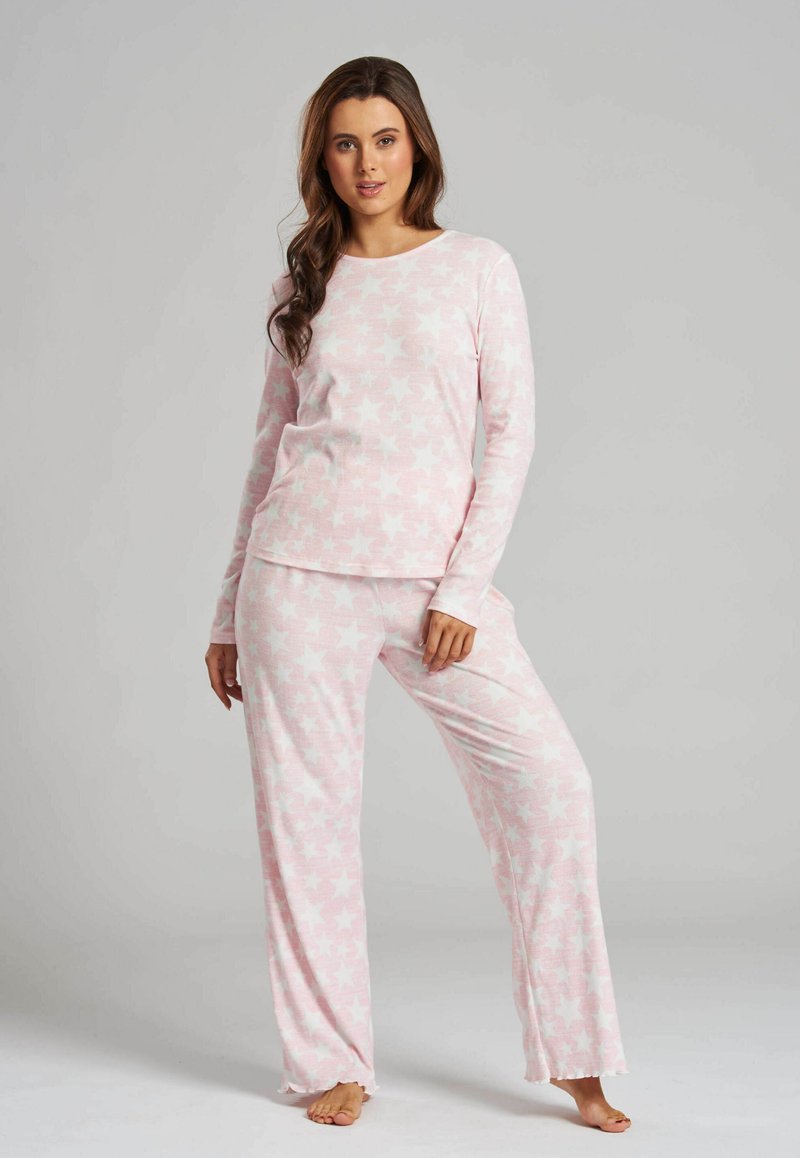 Light pink pajama set featuring long sleeves and relaxed-fit pants, adorned with a star pattern, made from soft, textured fabric.