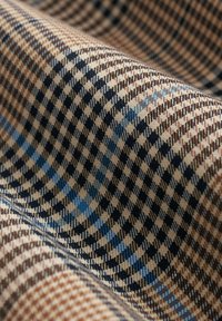 Geweven stof met een geruit patroon in bruin, beige en blauwe tinten; textuur met een zachte, gladde afwerking.