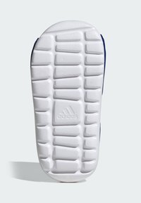 Podeszwa buta Adidas ma teksturowany biały gumowy wzór z prostokątnymi bieżnikami i wytłoczonym logo na środku.