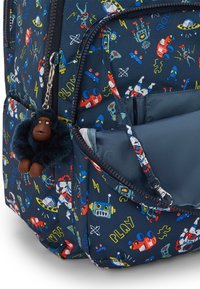 Zaino navy con illustrazioni giocose di robot e temi spaziali, un portachiavi a forma di gorilla in peluche e molteplici scomparti con zip.