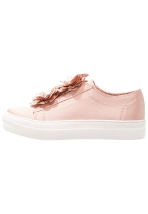 Baskets roses claires à enfiler avec semelle blanche, décorées d'appliques florales superposées sur la tige.