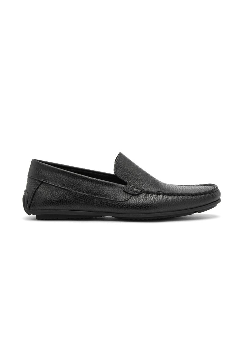 Mocasines de cuero negro con un acabado texturizado, diseño sin cierres y suelas blandas. Presenta detalles de costura a lo largo de la parte superior y bordes suaves.