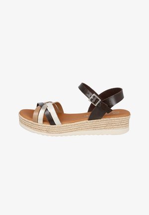 Sandalia plataforma para mujer con suela de yute trenzado, correa marrón en el tobillo con hebilla, y tiras cruzadas en el empeine en tonos beige, blanco y negro.