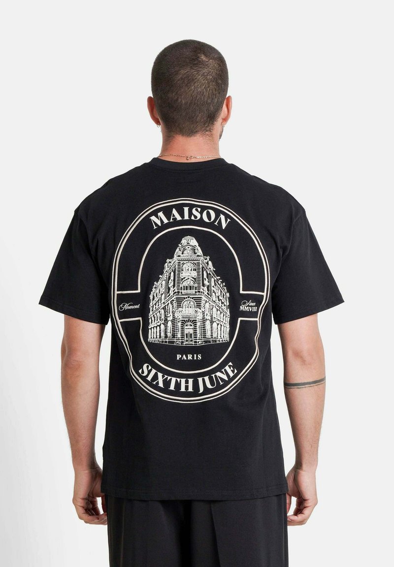 Zwarte katoenen t-shirt met een grote wittearchitectonische afbeelding op de achterkant, met de tekst "MAISON" en "SIXTH JUNE", korte mouwen.