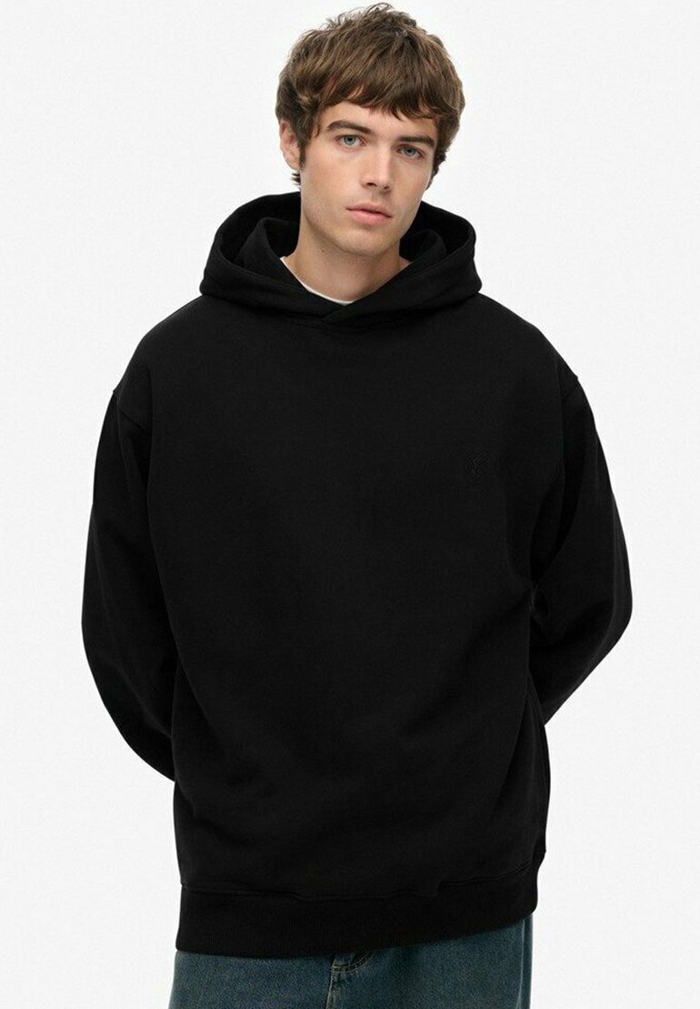 Sudadera negra con capucha que cuenta con cordones y bolsillo canguro, hecha de una tela suave con un corte relajado y puños de canalé. Diseño simple sin patrones.