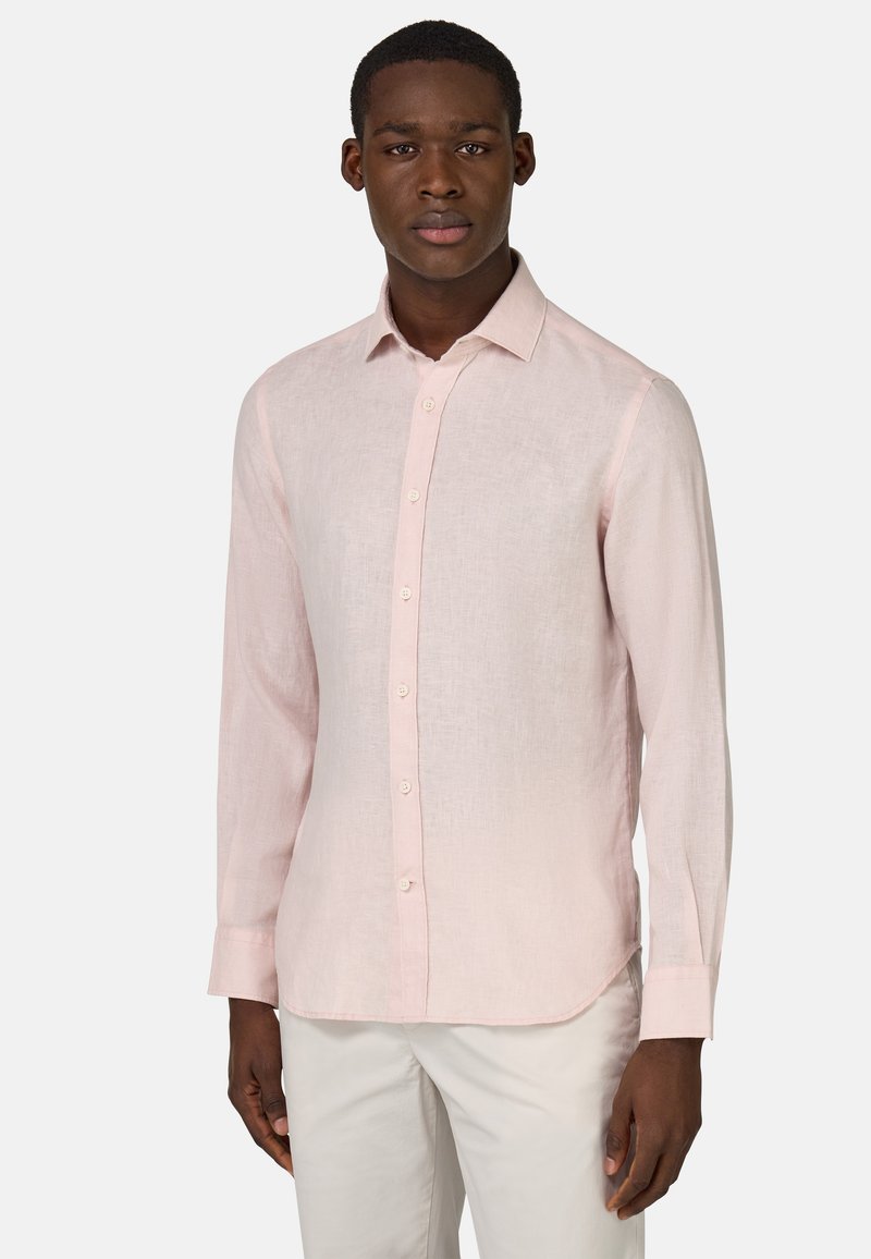 Camicia in lino rosa chiaro con colletto a button-down e maniche lunghe. Presenta una leggera texture e orlo arrotondato, abbinata a pantaloni chiari.