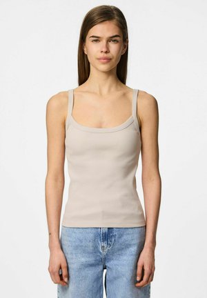 Canotta beige a costine con scollatura quadrata e spalline sottili, abbinata a jeans blu a vita alta. Texture liscia.