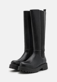 Schwarze knielange Stiefel aus glattem Leder mit einer robusten Gummisohle, ausgestattet mit elastischen Seitenpaneelen und kontrastierendem weißen Nähten.