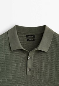 Polo en maille à manches courtes vert olive avec motif texturé, deux boutons et col, étiqueté Massimo Dutti.