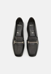 Czarne płaskie buty z siateczkowego materiału, kwadratowy rynek, srebrne dekoracyjne elementy oraz wyłożone podeszwy. Marka: Tamaris, model: Touch It.