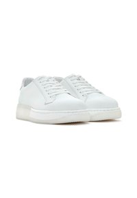 Baskets blanches en cuir avec un bout rond, des lacets plats et une épaisse semelle transparente. Présente des coutures minimalistes et une texture lisse.