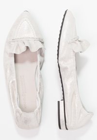 Ballet flats argentati con punta affusolata, dettaglio di ruffle, accentuazione di perline argentate e suola nera. Materiale morbido con texture liscia.