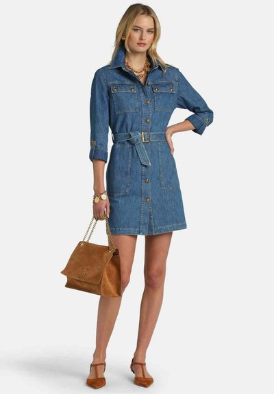 Denimskjortekjole i blå, med lange ærmer, knaplukning foran, to brystlommer og et bælte i taljen. Suppleret med en brun taske.