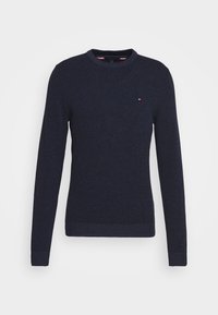Granatowy sweter dzianinowy z okrągłym dekoltem, długimi rękawami oraz ściągaczami na mankietach i dole. Posiada mały akcent logo na klatce piersiowej.
