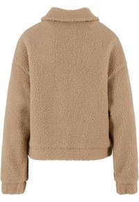 Giacca in pile beige morbida e soffice con colletto alto, spalle scese e maniche lunghe. Presenta un esterno testurizzato e morbido ed è di lunghezza cropped.