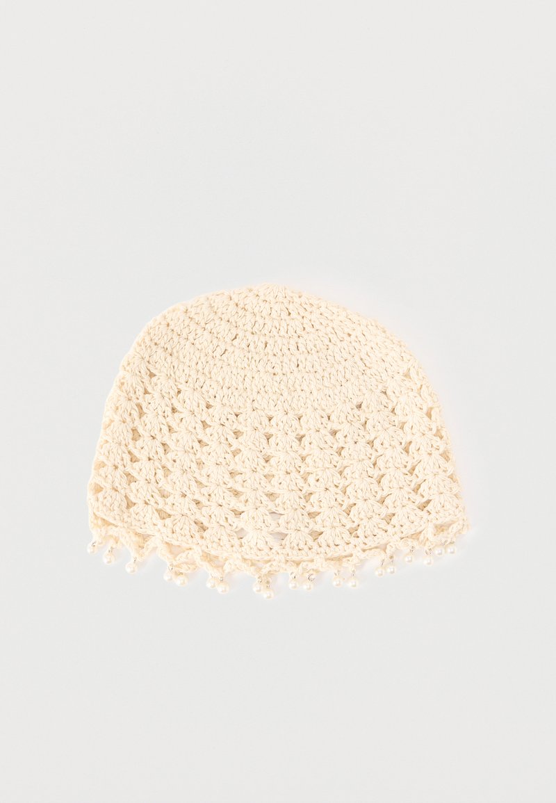 Άσπρο σκουφάκι από βελονάκι με ανοιχτό σχέδιο και μικρές διακοσμητικές χάντρες κατά μήκος του κάτω άκρου σε λευκό φόντο.