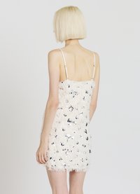 Vestito corto aderente in pelliccia sintetica bianca con paillettes argento. Presenta spalline sottili regolabili e una finitura testurizzata.