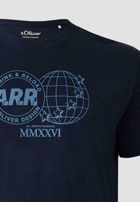 T-shirt s.Oliver bleu marine avec un graphique globe et étoile bleu clair, texte circulaire "Think & Reload", lettres "A.R.R" et chiffres romains "MMXXVI".