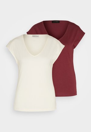 Deux t-shirts à col en V : l'un en crème avec des manches courtes, l'autre en bordeaux. Les deux sont en tissu en coton doux et ont une coupe décontractée.