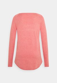 Pull à manches longues de couleur corail douce, avec un col rond, une texture lisse et un ourlet incurvé en bas.