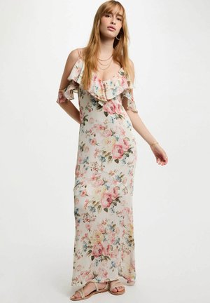 Maxi abito in tessuto leggero con ruches scoperte sulle spalle. La stampa floreale presenta fiori rosa e blu su uno sfondo crema.