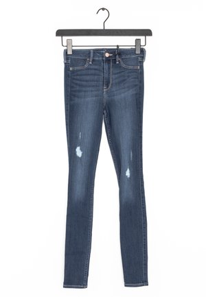 Smala jeans i medelblå denim med en lätt blekning, slitna detaljer på framsidan och en standardmidjeband med en metallknapp.