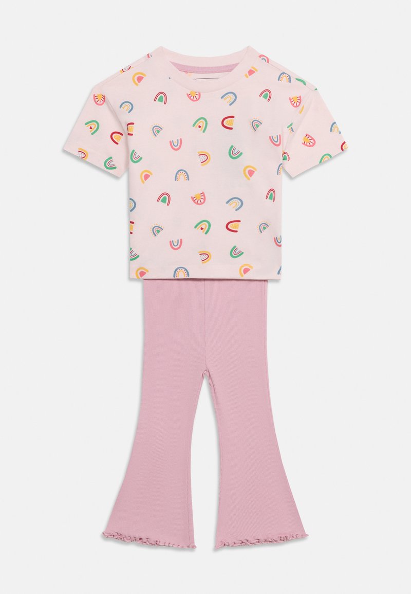 Detský dvojdielny outfit s ružovým tričkom s krátkym rukávom zdobeným farebnými dúhami a svetloružovými zvonovými nohavicami so zúbkovanými lemami.
