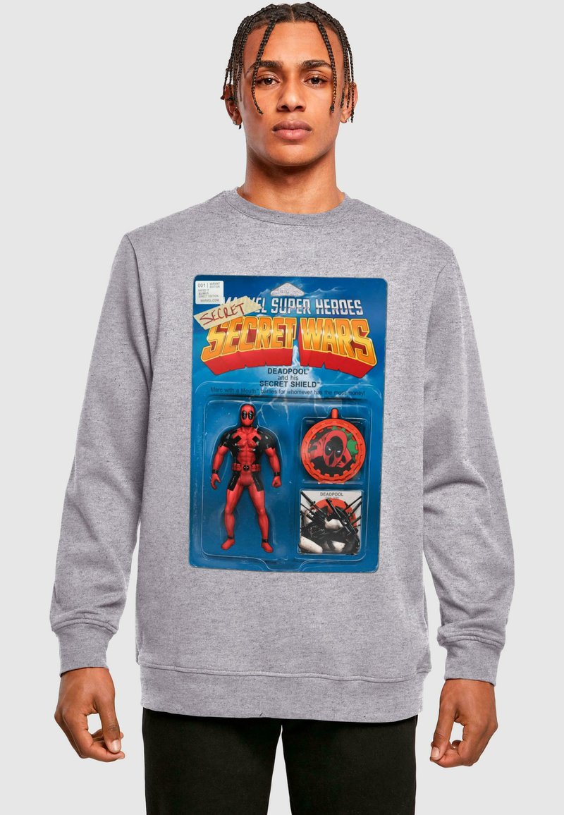 Pilkas džemperis su spalvinga grafika, vaizduojančia Deadpool veiksmų figūrėlę pakuotėje, su detalėmis apie priedus ir tekstu.