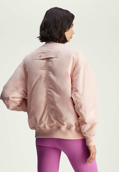 Light pink bomber jacket with a satin finish; features ribbed cuffs and hem, and an embossed logo tag on the back.