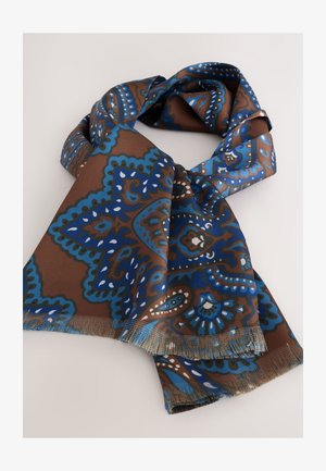 Pruun sall, millel on keerukad sinised ja valged mustrid, pehme kangas ja turritatud servad. Disainitud voolava ja elegantse langevusega.