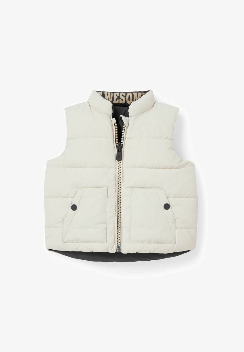Lekki puchowy bezrękawnik w kolorze kremowym z czarnymi akcentami. Posiada zamek błyskawiczny z przodu, wysoki kołnierz i dwie kieszenie naszywane. Pikowana tekstura.