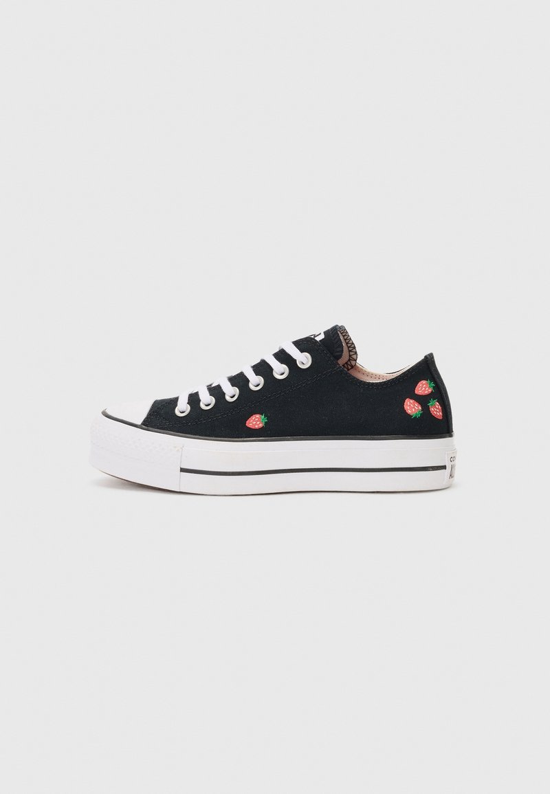 Basket basse noire avec lacets et semelle blancs, décorée de petits motifs de fraises rouges sur le côté et le talon.