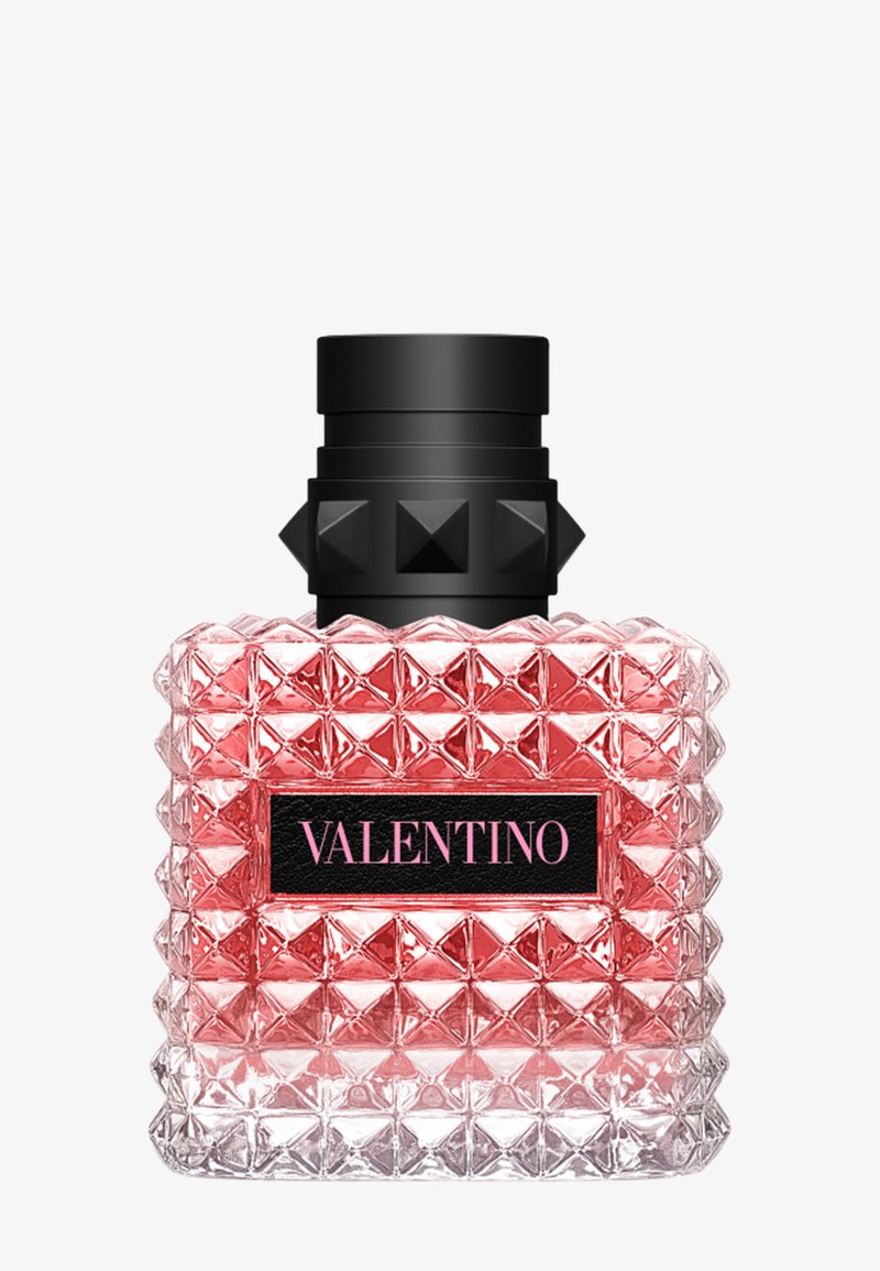 Square pink Valentino perfume bottle with textured pyramid studs and a black cap with raised studs.