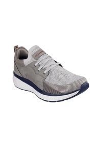 Zapatilla gris claro con parte superior de tela texturizada, acentos de cuero liso en contraste, entre suela blanca y suela azul oscura. Diseño con cordones.