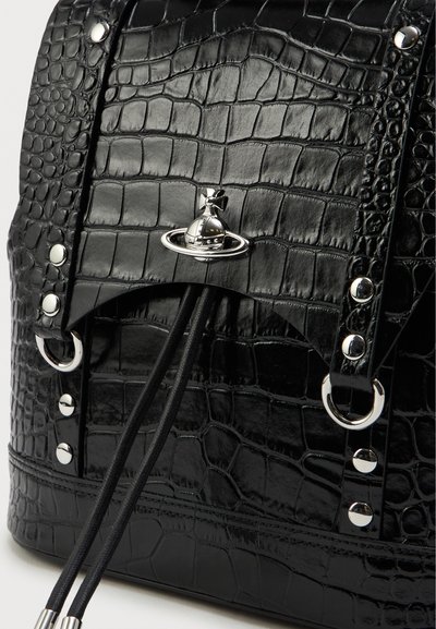 Μαύρο σακίδιο με ανάγλυφη υφή κροκοδείλου και μεταλλικές λεπτομέρειες, διαθέτει κλείσιμο με κορδόνι, διακοσμητικά αξεσουάρ σε σχέδιο πλανήτη και κυκλικούς μεταλλικούς κρίκους.