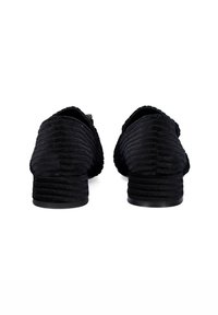 Zapatos negros con textura acanalada, tacón bajo apilado y punta redondeada. Incluyen un cierre con cremallera en el talón para facilitar su uso.