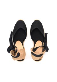 Espadrillas in tessuto nero con cinturino alla caviglia intrecciato color beige, design aperto davanti e nastri neri. Suola in juta naturale con finitura testurizzata.